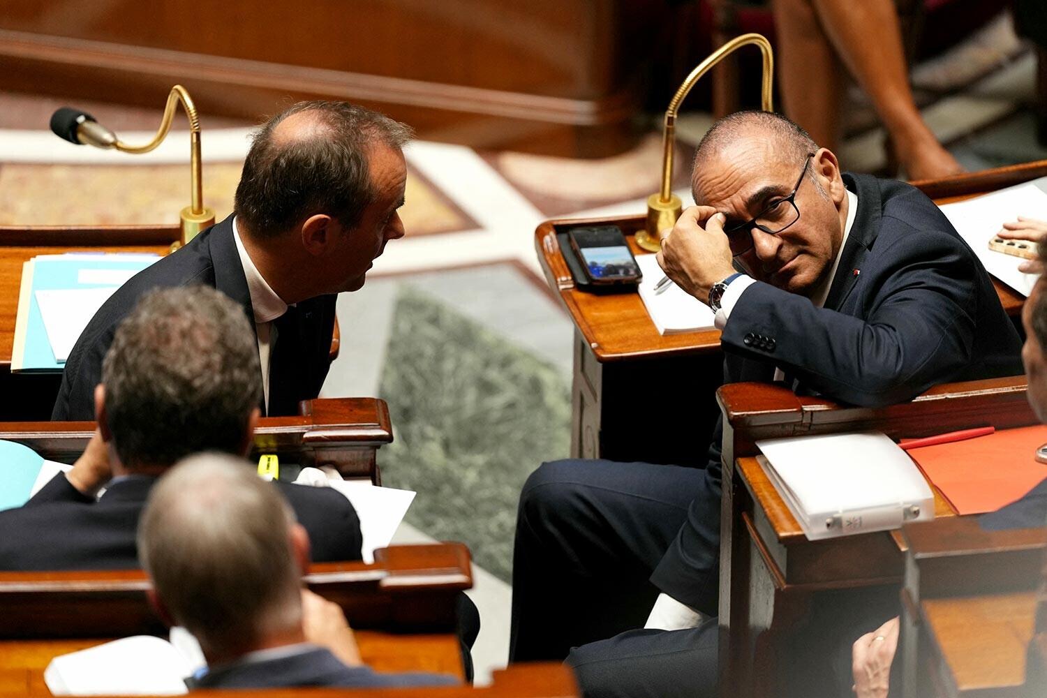 photo prise à l'assemblée nationale. Sebastien Lecornu à gauche discute avec Laurent Nunez à droite. Les deux hommes semble en difficultés et soucieux